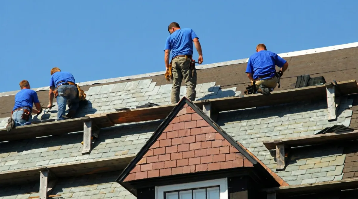 Roof replacement in progress with a team of professional contractors installing new shingles on a residential home in Des Moines, IA